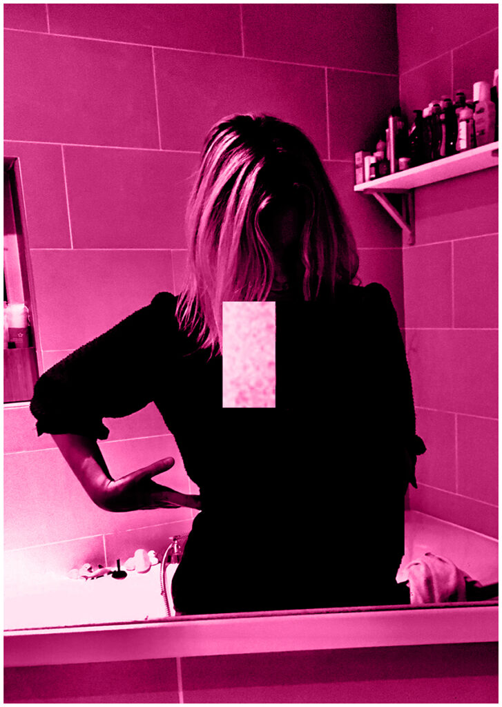 Hot pink tint on A2 portrait sized black and white image of woman dressed in all black, stood reflected in a bathroom mirror. Her head is bowed and her left arm is positioned on her waist. A pale pink rectangle from another image is superimposed below her face as if a tear.