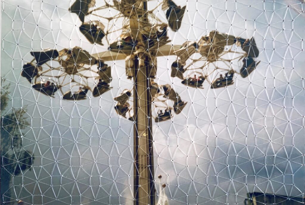 An image of a photograph of a fairground ride called the Condor, taken from below. The photo has been embroidered using invisible thread with a repetitive blackwork pattern than mirrors the shape of the carriages in the ride